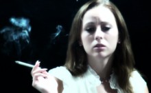 Cute brunette is having a smoke while talking to the camera